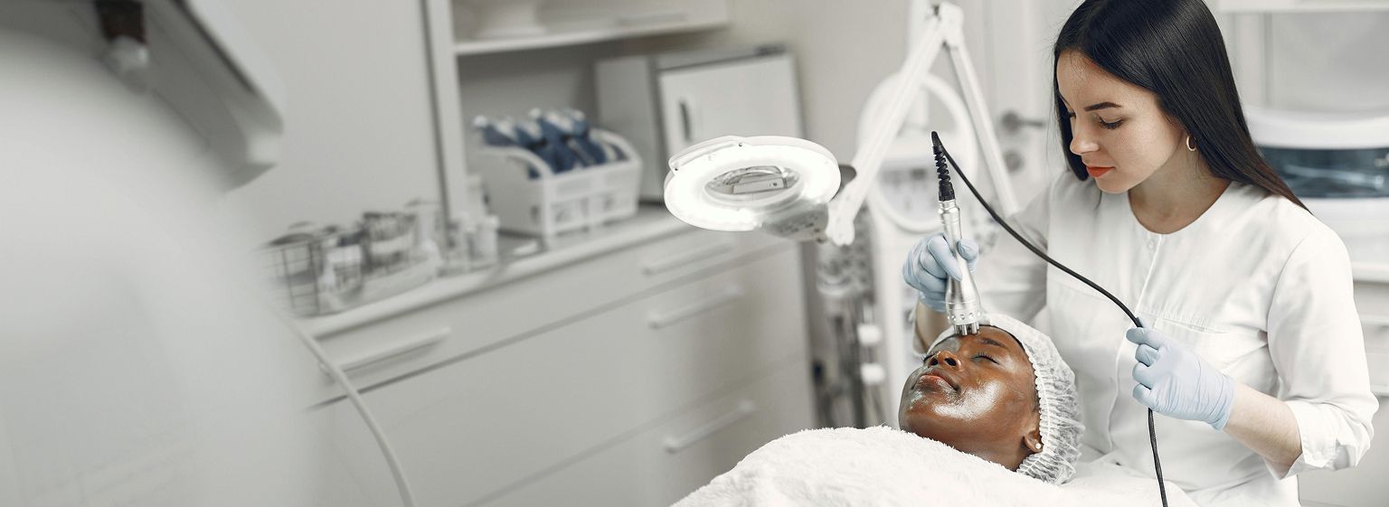 Aesthetic provider performing a facial skin treatment on a client in a clinical studio