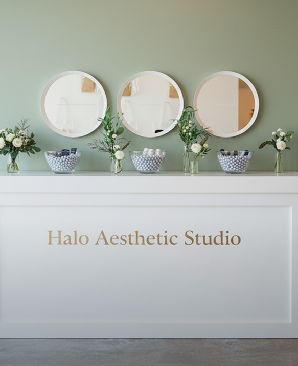 Halo Aesthetic Studio treatment room with round mirrors and fresh flowers