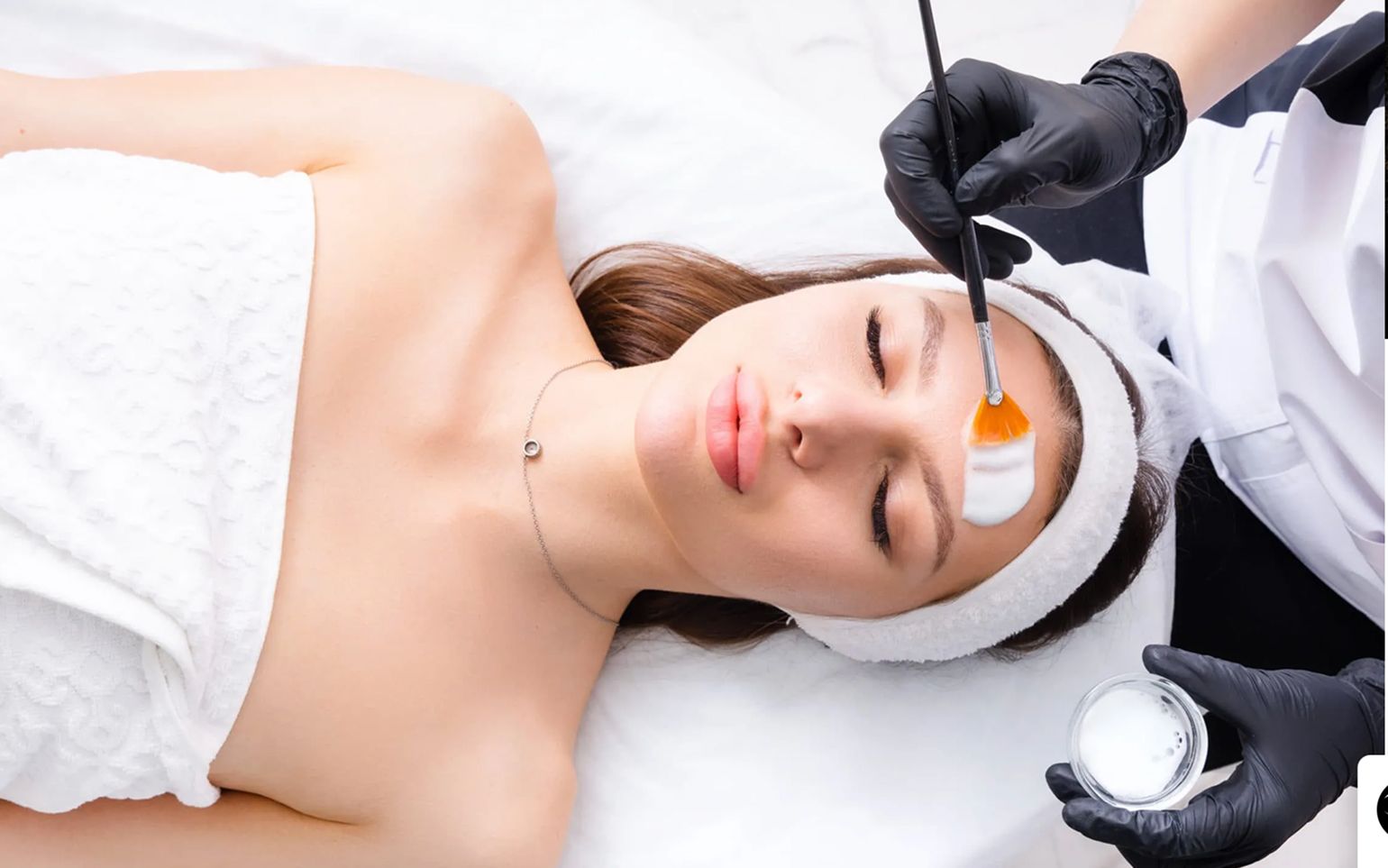 Client receiving a professional chemical peel applied with a brush
