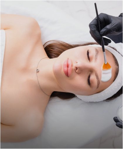Provider applying a chemical peel to a client's face with a brush