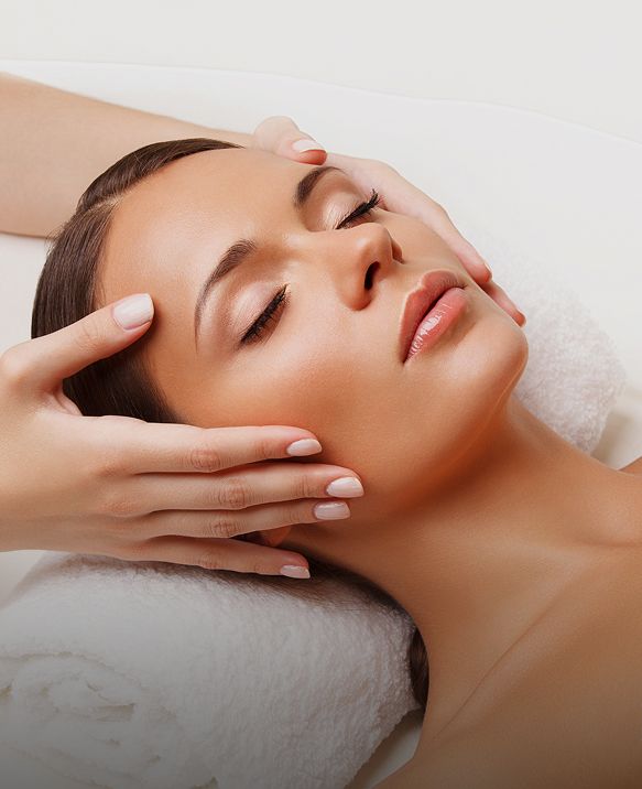 Woman with closed eyes enjoying a relaxing facial massage