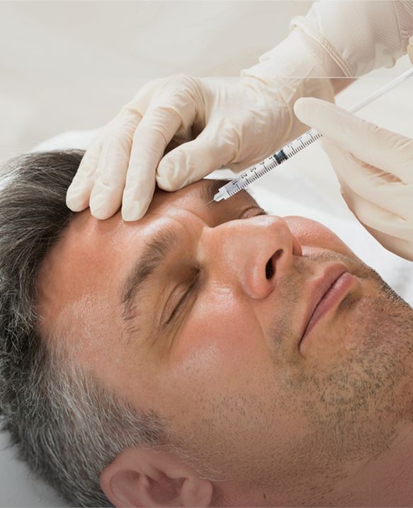 Man receiving a neuromodulator injection between the eyebrows